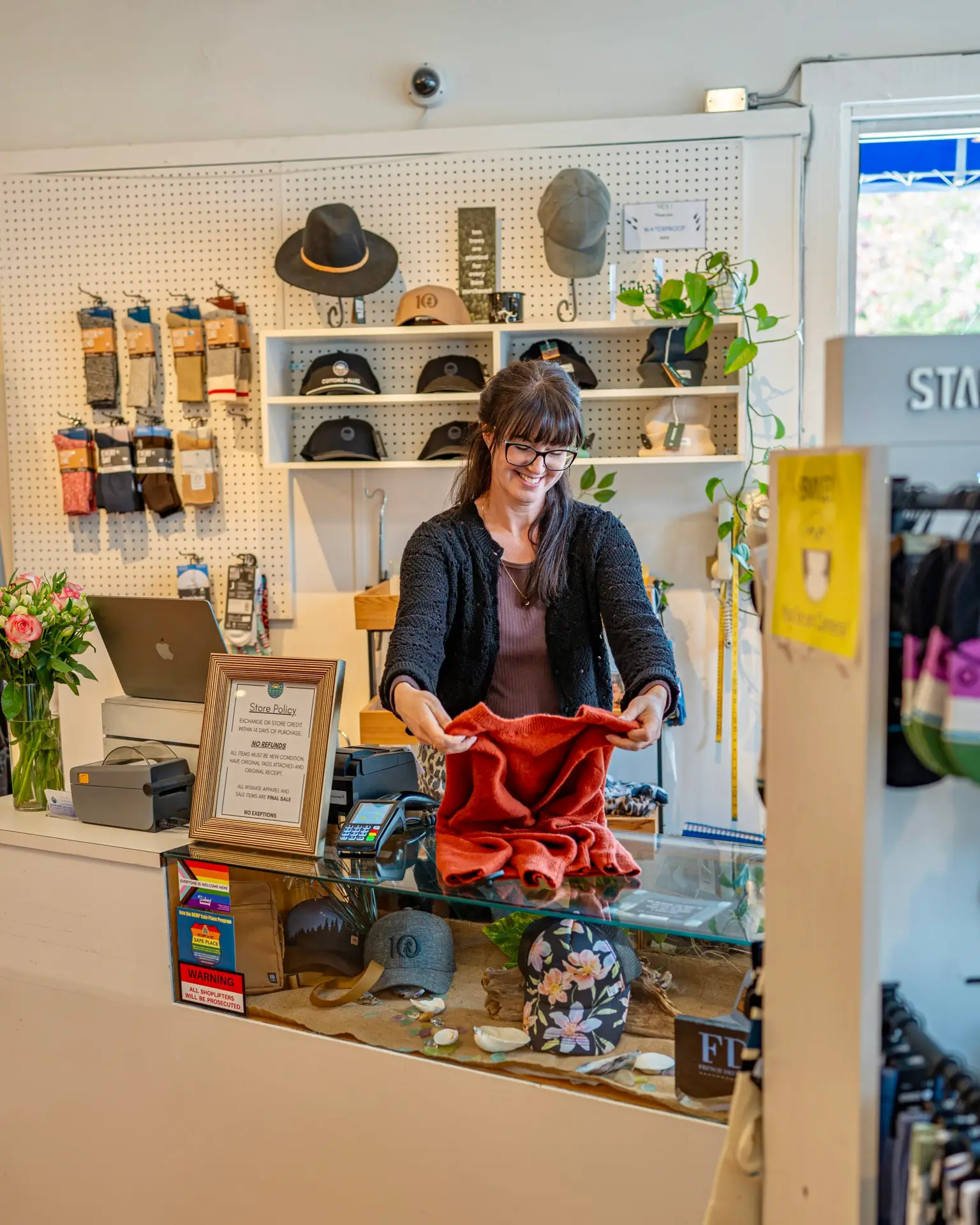 Owner of Cottons & Blues folding clothing at desk